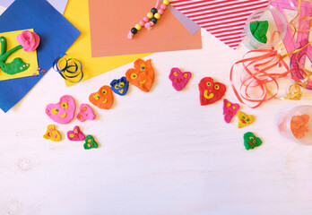 Child made many funny hearts with smile. hearts from colorful plasticine, Concept of happy family having fun. Place for text. Kid craft. Home Education game. Educational and entertaining with children