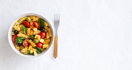 Pasta salad with tomatoes, zucchini, olives and spinach. Healthy eating. Vegetarian food.