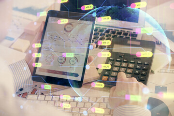 Double exposure of man's hand holding and using a digital device and data theme hologram drawing. Technology concept.