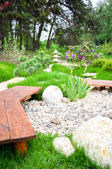 Beautiful green landscape design, botanic garden park with decorative flower bed with pebbles,...