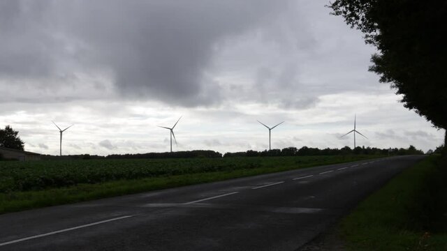 field of wind turbines, inside of nature, in a field full of wind turbines, in a cloudy day.