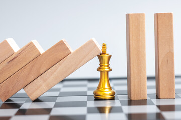 wooden Blocks or Dominoes falling to golden Chess King figure. Business, Risk Management, Solution, economic regression, Insurance