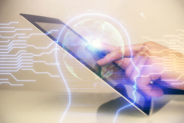Double exposure of man's hand holding and using a digital device and brain hologram drawing. Data...