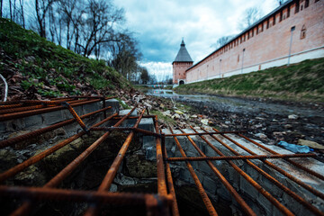 an old dried-up pond in mud and garbage. an abandoned park near the old fortress. desolation in the...
