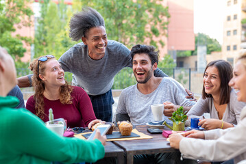 group of multiethnic friends having breakfast with coffee, cappuccino and chocolate muffin, meeting...