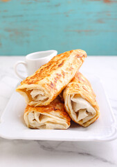Tasty stuffed pancakes crepes with meat and sauce. Food photography.