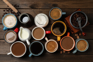Cups of fresh aromatic coffee on wooden table, flat lay