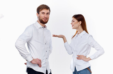 a man and a woman in identical shirts are gesticulating with their hands on a light background.