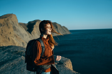 beautiful traveler with a backpack in nature near the sea