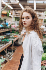 Young pretty girl in green spring garden. Natural beauty, organic lifestyle, plants and flowers concept	