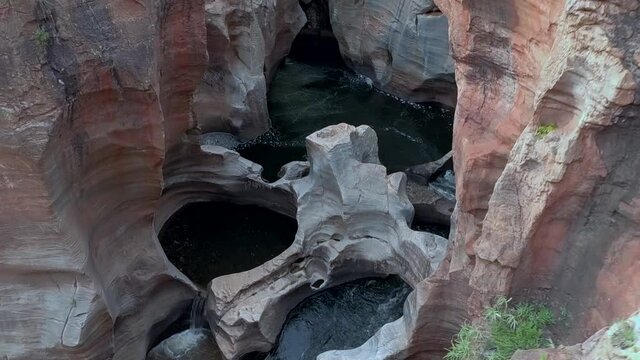 Desending aerial HD drone footage of beautiful natural rock formations, Bourke's Luck Potholes, hewn by centuries of water flow by the Blyde River in Graskop, Mpumalanga, South Africa.
