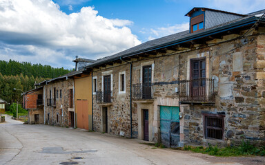 Street view of traditional architecture in the historic village of Arganza in the Bierzo region of Spain, with home facades built in natural stone.