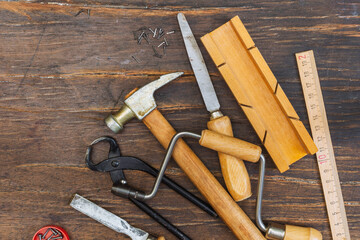 Vintage carpentry tools on a dark rustic wood background. Overhead, close-up, copy of the space