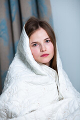 Young beautiful white woman awaking in light room. Relaxed woman lying in bed and drink tea. Good morning concept. Russian girl.