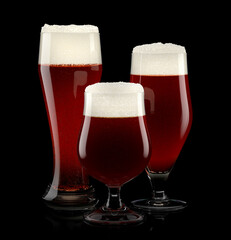 Set of fresh stout beer glasses with bubble froth isolated on black background.
