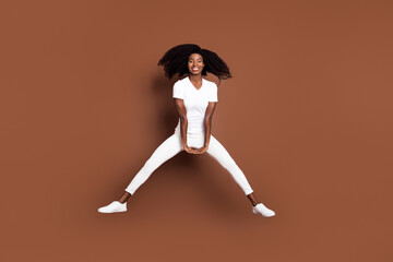 Fototapeta na wymiar Full length body size photo of cool funky model jumping up careless isolated on pastel brown color background