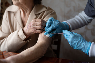 Nurse making vaccine injection to elderly patient - obrazy, fototapety, plakaty