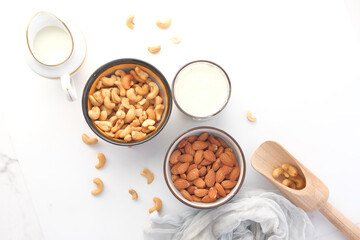  almond , cashew nut in glass bowl and milk on white background 