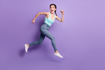 Fototapeta na wymiar Full body profile photo of cheerful lady run look back wear top jeans isolated on purple color background