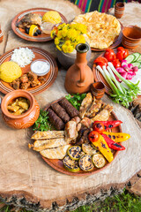 Homemade Romanian Food with grilled meat, polenta and vegetables Platter on camping. Romantic...