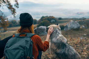 woman outdoors travel next to dog friendship landscape