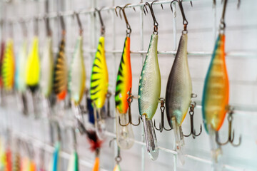 Lures for catching a predator in a shop window. Plastic wobblers with large tees. Selective focus