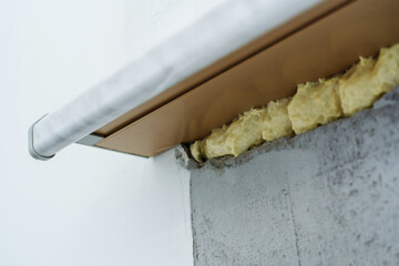 Installation of a plastic window sill using polyurethane foam. Close-up