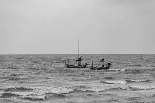 .The black and white image of two fishing boats. In the middle of the sea