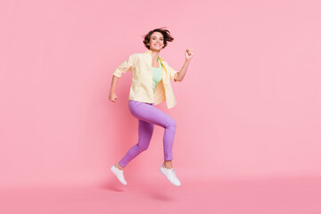 Fototapeta na wymiar Full size profile photo of optimistic brunette lady jump run wear shirt trousers sneakers isolated on pastel pink background