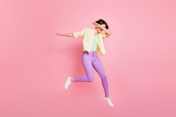 Fototapeta na wymiar Full size profile photo of optimistic brunette lady jump dance dab wear shirt trousers sneakers isolated on pastel pink background