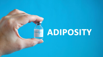 Adiposity text in the hand of a man holding a vial with a cure for healing
