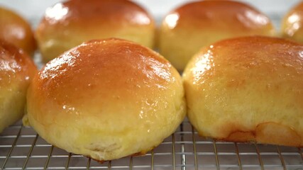 Step by step. Cooling freshly baked brioche buns on a kitchen cooling rack.