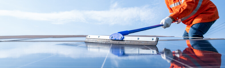 Selective focus mop of technician or worker operating use a mop cleaning solar panels at generating...