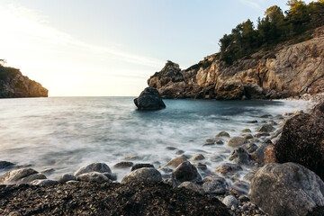 rock formation in sea against sky during sunset