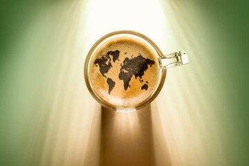 coffee cup with world map sign, top view on background with sunlight.
