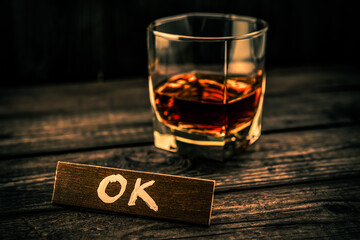 Glass of brandy with the wooden plank on it is an inscription 