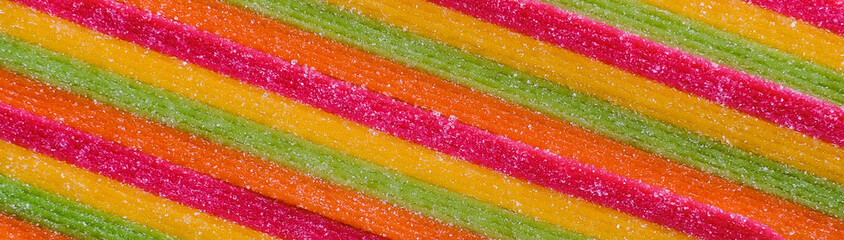 Closeup of bright tasty sour sweet candy texture, background yellow