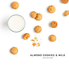 Glass of milk and almond cookies amarettini creative layout.
