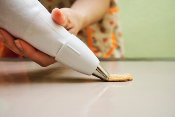 Close-up of a housewife's hands holding a piping bag while baking cookies.