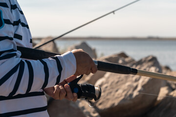 Side view of a person fishing with a fishing rod.