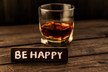 Glass of brandy with the wooden plank on it is an inscription 