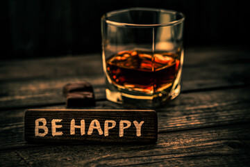 Glass of brandy with chocolate and the wooden plank on it is an inscription 
