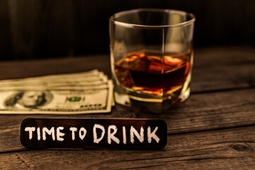 Glass of brandy with money and the wooden plank on it is an inscription 