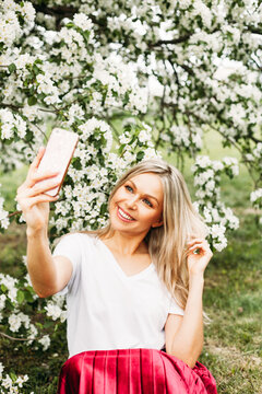 A girl with a phone in her hand takes pictures of herself, selfies, photos for the Internet, social networks, communication with classmates, friends, mom, family, teenager