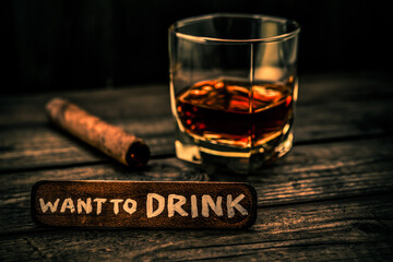 Glass of brandy with cuban cigar and the wooden plank on it is an inscription 