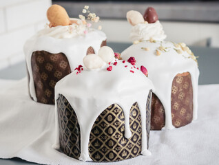 Homemade Easter cakes decorated with white sugar icing with drips, dried flowers and chocolate eggs