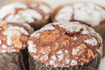 Traditional italian pastry panettone sprinkled with almond flakes top view