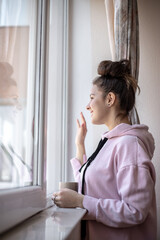 Young girl drinking coffee in a window