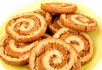 Beautiful cookies with a spiral pattern on a yellow plate.