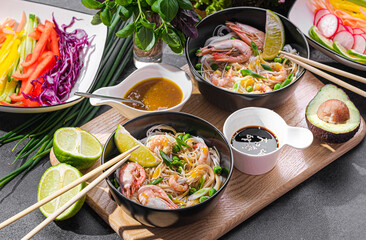 rice noodles. asian rice noodles in black plates with seafood and vegetables.
